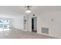 Open-concept living space with built-in shelving, wood floors, and sliding patio doors at 650 Island Way # 106, Clearwater Beach, FL 33767