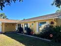 Yellow one-story house with white trim, attached garage, and landscaped front yard at 712 Gateway Ln, Tampa, FL 33613