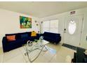 Living room with blue couches, glass coffee table, and decorative accents at 712 Gateway Ln, Tampa, FL 33613