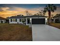 Modern home exterior at dusk, showcasing clean lines and curb appeal at 10300 Gifford Dr, Spring Hill, FL 34608