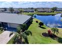 Lush landscaping, paver driveway, and lake view enhance this aerial view of the property at 1506 Bentwood Dr, Sun City Center, FL 33573