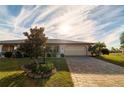 Attractive single-story home showcasing a manicured lawn and paver driveway at 1506 Bentwood Dr, Sun City Center, FL 33573