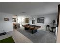Spacious living room featuring a pool table and views of the kitchen and dining area at 1506 Bentwood Dr, Sun City Center, FL 33573