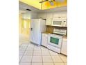 Galley kitchen with white cabinets, tile floors and modern appliances at 1660 S Lake Ave # 1, Clearwater, FL 33756