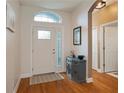 Bright and spacious entryway with hardwood floors and a gray cabinet at 16828 Taylow Way, Odessa, FL 33556