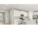 Modern kitchen with white cabinets, stainless steel appliances, and a center island at 17901 Solstice Ave, Venice, FL 34293