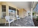 Relaxing front porch with wicker chairs and paver stone flooring at 6474 Pine Meadows Dr, Spring Hill, FL 34606