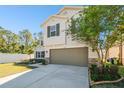 Two-story house with a neutral color scheme, two-car garage, and landscaped front yard at 10703 Aldo Moro Dr, Wimauma, FL 33598