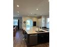 Modern kitchen with large island, dark cabinets, and stainless steel appliances at 1449 Kaffir Lily Ct, Trinity, FL 34655
