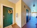 Building hallway with green door and sunflower wreath at 2724 Via Murano # 633, Clearwater, FL 33764