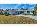 Ranch style home with teal exterior, green accents, and a brick driveway at 5970 Hillside St, Seminole, FL 33772