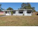 Gray house with a well-maintained lawn and mature trees at 10273 109Th Ave, Largo, FL 33773
