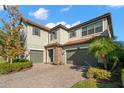 Two story house with a three car garage and paver driveway at 17907 Woodland View Dr, Lutz, FL 33548