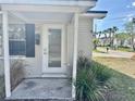 Charming home featuring a glass front door with a white brick facade, offering a warm, inviting welcome at 3211 S Ferdinand Ave, Tampa, FL 33629