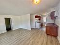 Bright living room featuring stylish flooring, and a partial view of the kitchen with white appliances at 3211 S Ferdinand Ave, Tampa, FL 33629