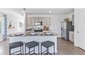 Modern kitchen with gray cabinets, granite island, and stainless steel appliances at 36068 Sunflower Hill Dr, Zephyrhills, FL 33541