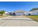 Front view of a single-story house with a garage and a brick facade at 545 Lillian Dr, Madeira Beach, FL 33708