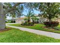 House with mature trees, lush landscaping, and a welcoming front entrance at 9901 Tree Tops Lake Rd, Tampa, FL 33626