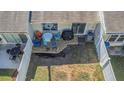Private fenced-in patio with outdoor seating, an umbrella, and a grill perfect for relaxation and entertaining at 381 Estero Ct, Safety Harbor, FL 34695