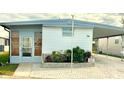 Mobile home with carport, paved driveway, and landscaping at 9790 66Th N St # 74, Pinellas Park, FL 33782