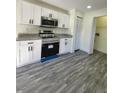 Modern kitchen with white cabinets, granite countertops, and stainless steel appliances at 1302 E Annie St, Tampa, FL 33612