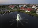 Aerial view of a lake with a fountain in a neighborhood with homes and water access at 1414 Alhambra Dr, Apollo Beach, FL 33572