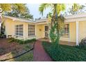 Inviting front porch with brick walkway and tropical plants at 1901 Oakdale S Ln, Clearwater, FL 33764