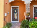 Townhouse entry with brown door, wreath, and landscaping at 20388 Lagente Cir, Venice, FL 34293