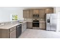 Modern kitchen with stainless steel appliances and gray cabinets at 475 Winwood Ct, Port Charlotte, FL 33954