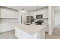 Modern kitchen with stainless steel appliances and a spacious quartz countertop island at 10320 Cross River Trl, Parrish, FL 34219