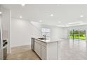 Open-concept kitchen with island seamlessly connects to living area, filled with natural light at 10320 Cross River Trl, Parrish, FL 34219