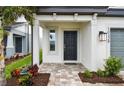 Welcoming front entrance showcasing a black front door, sidelight window, and tasteful landscaping at 10328 Cross River Trl, Parrish, FL 34219