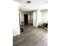 Bright and airy living area with wood-look flooring and access to other rooms at 11253 Leland St, Spring Hill, FL 34609