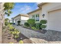Landscaped walkway leading to a garage and front door at 15314 Valencia Del Sol St, Wimauma, FL 33598