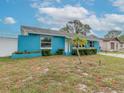 Charming blue house with a palm tree in the front yard at 2609 Fulton Sw St, Largo, FL 33774