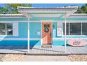 Attractive front entrance with coral door and surfboard decor at 6500 7Th S Way, St Petersburg, FL 33705