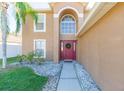 Front entrance with red door, walkway, and landscaping at 25028 Hyde Park Blvd, Land O Lakes, FL 34639
