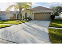 Front view of a one-story house with a two-car garage at 31216 Masena Dr, Wesley Chapel, FL 33545