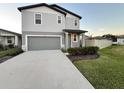 Two-story house with gray siding, a two-car garage, and a landscaped front yard at 3314 Fresno Pl, Zephyrhills, FL 33541