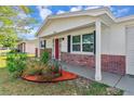 Inviting front porch with red door entry at 4838 Longwood Ave, Holiday, FL 34690