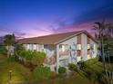 Evening view of condo building with palm trees and water at 4859 Independence Dr, Bradenton, FL 34210