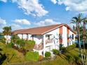 White condo building with brown roof, stairs, and landscaping, near water at 4859 Independence Dr, Bradenton, FL 34210