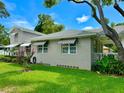 Side view of a charming house with a large lawn and striped awnings at 1003 Beverly Ave, Largo, FL 33770
