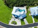 An aerial view of a modern home with a pool, lush lawn, and circular driveway with beautiful landscaping at 10101 Eagle Preserve Dr, Englewood, FL 34224