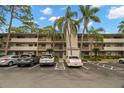 Condo building with parking spaces and tropical landscaping at 3038 Eastland Blvd # F205, Clearwater, FL 33761