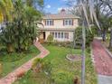 Aerial view of the home's landscaped front yard, brick walkway, and proximity to mature trees at 4611 W Lowell Ave, Tampa, FL 33629