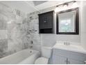 Updated bathroom with marble tile, a vanity, and a medicine cabinet at 5418 10Th Ave S, Gulfport, FL 33707