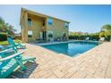 Backyard pool with patio seating and grill area in a fully fenced yard with mature landscaping at 5709 White Trillium Loop, Land O Lakes, FL 34639