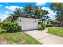 A charming home with a well-manicured lawn and an attached one-car garage at 980 5Th Ne Ave, Largo, FL 33770