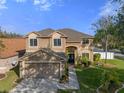 Two-story house with a large yard, double garage, and walkway at 19301 Sandy Springs Cir, Lutz, FL 33558